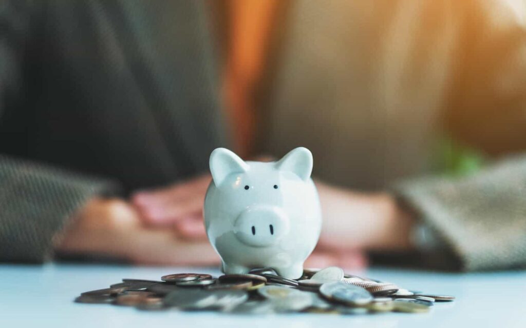 closeup image of a woman and piggy bank on pile